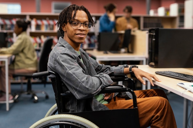Jovem negro cadeirante na biblioteca